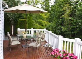 Outdoor patio setup on cedar wood deck with trees in background