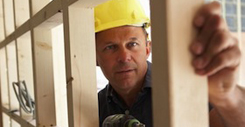 Construction Worker Building Timber Frame In New Home