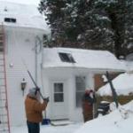 men removing snow from a house