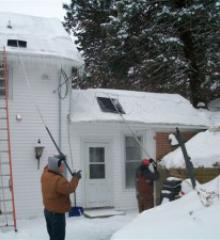 men removing snow from a house