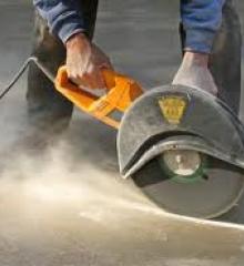 man cutting concrete with a saw
