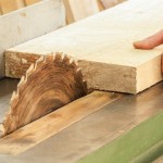 A close up of a woodworker's hand operating a piece of equipment