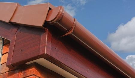close up of Brown wood effect PVCu or plastic soffit fascia and guttering on modern new build residential property