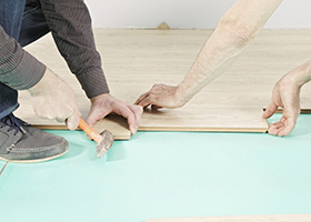 Men hands at flooring installation process
