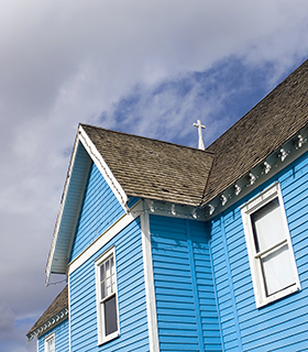 A country church with blue siding.