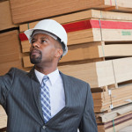 young male professional inspecting a lumber yard in suit and hard hat-10-25
