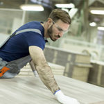 Man in lumber yard working with different types of lumber