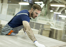 Man in lumber yard working with different types of lumber